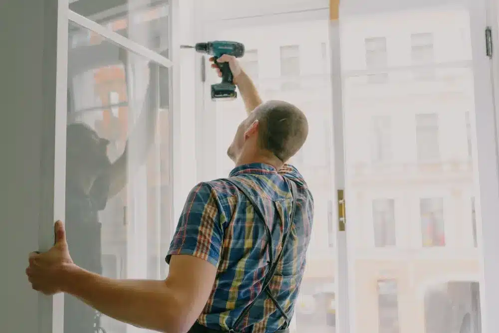 Technician installing aluminium bifold window in a Liverpool NSW residential kitchen