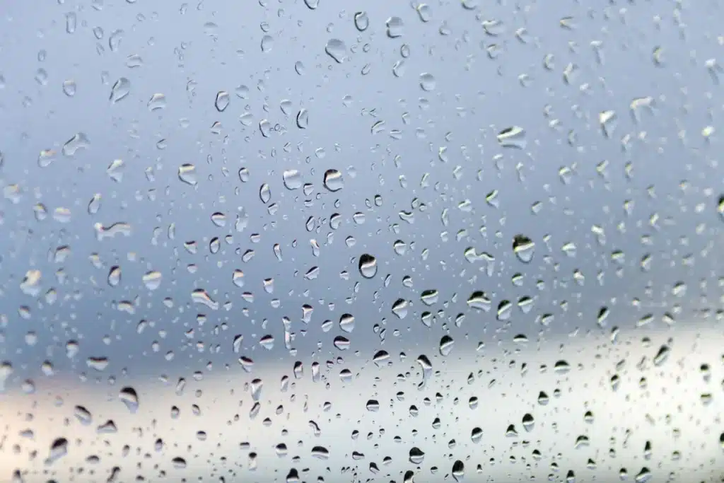Water droplets from condensation covering a single-glazed aluminium window in an Australian home