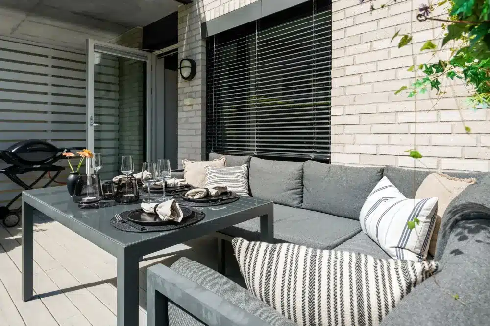 Contemporary alfresco living area with double glazed sliding doors and garden view