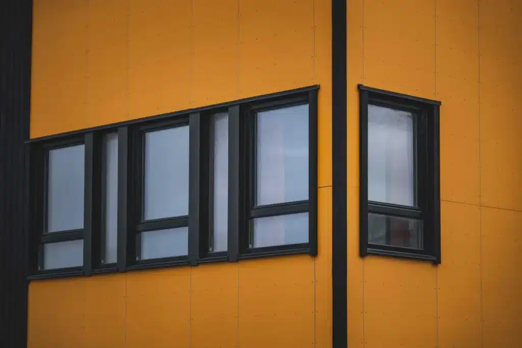 Cross-section diagram comparing low-E glass and double glazing in aluminium window frames