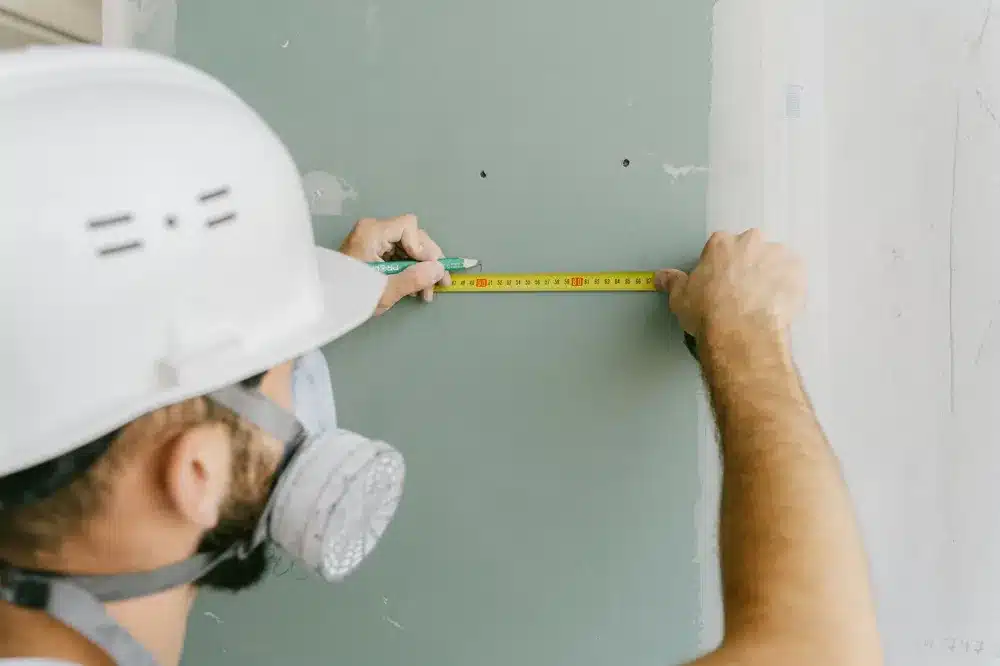 Shopfront Doors vs Apartment Entry Doors: The Differences 4 Tradesperson measuring aluminium door frame opening during on-site installation in Sydney