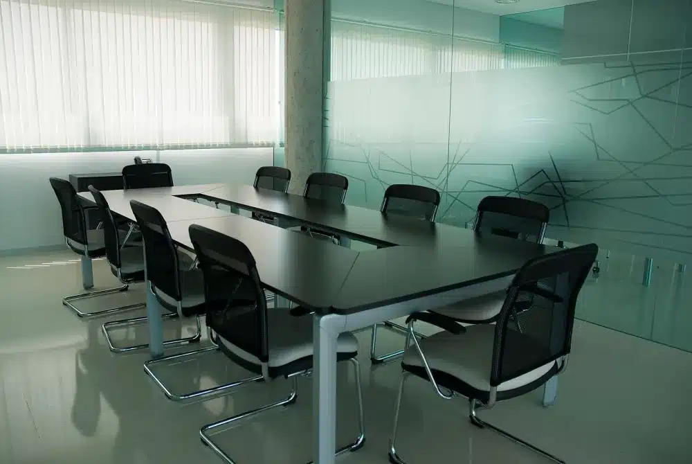 Frameless vs framed glass office partitions: Modern frameless glass partition wall creating a private meeting room in a commercial office